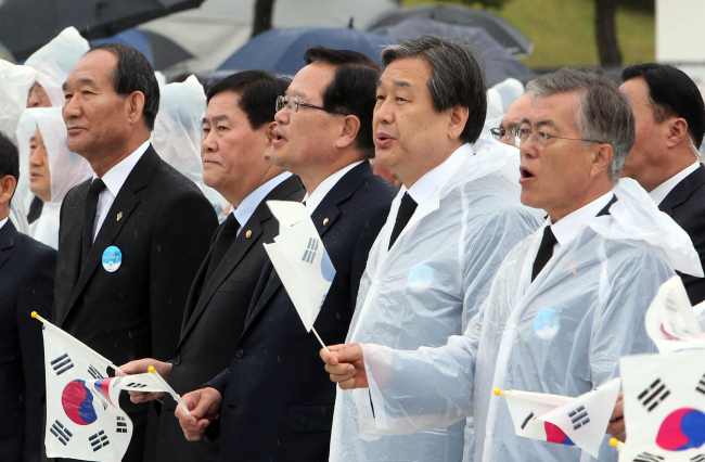 New Politics Alliance for Democracy chairman Moon Jae-in (from right), Saenuri Party chairman Kim Moo-sung and National Assembly Speaker Chung Ui-hwa sing the song “March for Our Beloved” at a memorial ceremony for the May 18 Democratic Uprising in Gwangju, Monday. Yonhap
