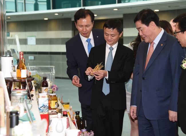 Alibaba Group head Jack Ma (center) looks at Korean food products in aT Center in southern Seoul after launching an online shopping platform in South Korea on Monday. At right is Finance Minister Choi Kyung-hwan.   Yonhap
Alibaba Group head Jack Ma (center) looks at Korean food products in aT Center in southern Seoul after launching an online shopping platform in South Korea on Monday. At right is Finance Minister Choi Kyung-hwan.   Yonhap