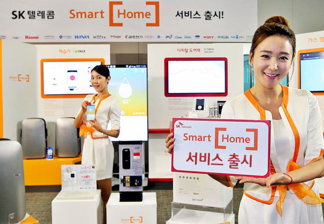 Models pose with electronics and home devices connected to SK Telecom’s Smart Home platform in Seoul Wednesday.    SKT