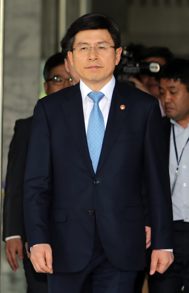 <YONHAP PHOTO-1447> 법무부 나서는 황교안 신임 국무총리 후보자 (과천=연합뉴스) 최재구 기자 = 황교안 신임 국무총리 후보자가 21일 정부 과천청사 법무부를 나서며 취재진의 질문에 답하고 있다. 2015.5.21 jjaeck9@yna.co.k/2015-05-21 12:27:29/ <저작권자 ⓒ 1980-2015 ㈜연합뉴스. 무단 전재 재배포 금지.>
Hwang Kyo-ahn
