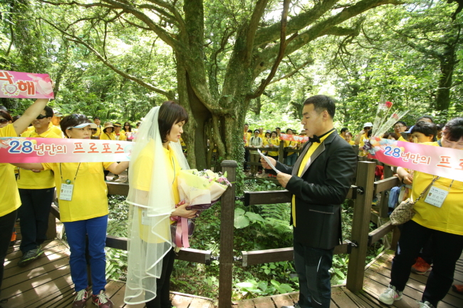A fire service worker and his wife pose during a three-day vacation camp for 70 fire service personnel and their spouses on Jejudo Island held Thursday to support the emergency services.   S-Oil