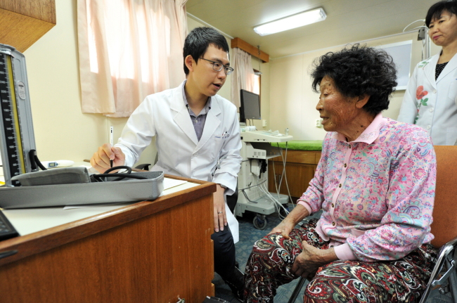 A patient from Jangbyeongdo Island, one of 138 remote Korean islands that do not have any medical facilities, talks to a doctor on a state-run hospital ship that visits her island about five times a year.   The Ministry of Health and Welfare