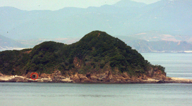 The image dated May 28, 2009, shows Gal Island, north of the Northern Limit Line. In the red circle is a cave camp where the North Korean military is suspected to have deployed shore batteries. The insert photo shows a 122-millimeter multiple rocket launcher. (Yonhap)