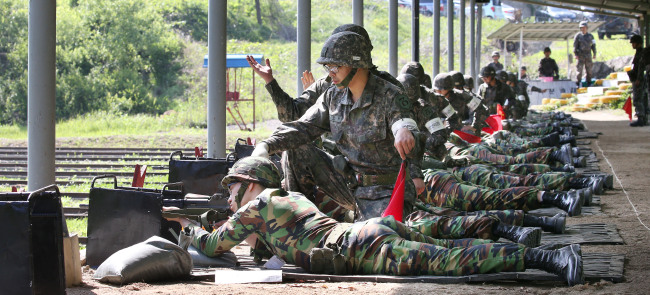 Reservists participate in shooting drills under the guidance of instructors in the 73rd Army division in Namyangju, Gyeonggi Province, on May 20. The military introduced one-on-one assistance throughout the exercise in the wake of a fatal shooting incident earlier this month.   Yonhap