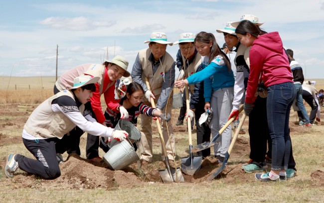 Employees of Korean Air and Mongolian residents plant trees in the Baganuur Desert in Mongolia on Tuesday.   Korean Air