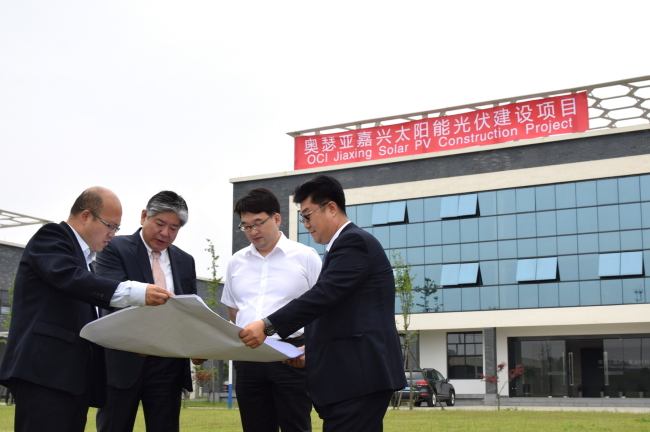 OCI CEO Lee Woo-hyun (third from left) looks at the construction site for a new solar plant scheduled for construction in Jiaxing, China, Wednesday. OCI plans to construct 20 megawatts worth of solar panels in Jiaxing by 2016.   OCI
OCI CEO Lee Woo-hyun (third from left) looks at the construction site for a new solar plant scheduled for construction in Jiaxing, China, Wednesday. OCI plans to construct 20 megawatts worth of solar panels in Jiaxing by 2016.   OCI