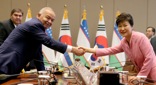 President Park Geun-hye shakes hands with visiting Uzbekistan President Islam Karimov during their meeting at Cheong Wa Dae in Seoul on Thursday.    Yonhap