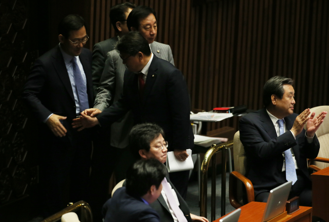 <YONHAP PHOTO-0481> 박수치는 김무성 (서울=연합뉴스) 진성철 기자 = 공무원연금 개혁안이 통과된 29일 새벽 국회 본회의에서 새누리당 김무성 대표, 유승민 원내대표 등이 회의가 산회되자 박수치고 있다. 2015.5.29 zjin@yna.co.kr/2015-05-29 05:05:20/ <저작권자 ⓒ 1980-2015 ㈜연합뉴스. 무단 전재 재배포 금지.>
Saenuri Party leader Rep. Kim Moo-sung (right) claps as the plenary session wrapped up after some 60 bills, including the contentious civil pension reform, were endorsed early Friday at the National Assembly.   Yonhap