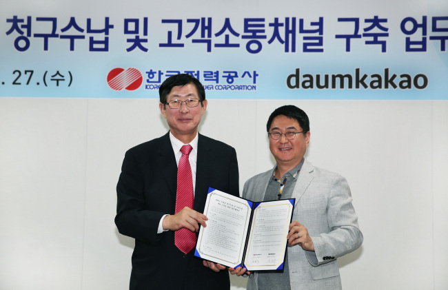 KEPCO president Cho Hwan-eik (left) and Daum Kakao co-CEO Lee Sir-goo pose after signing an MOU in Seoul on Thursday.   KEPCO