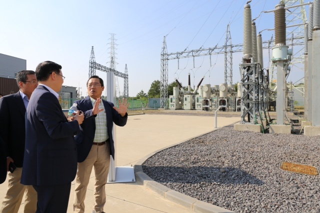LS Group chairman Koo Ja-yeol (right) speaks with staff membes during his visit to the solution provider’s High-Voltage Direct Current Smart Center in Hallim, Jejudo Island, on Friday.   LS Group
