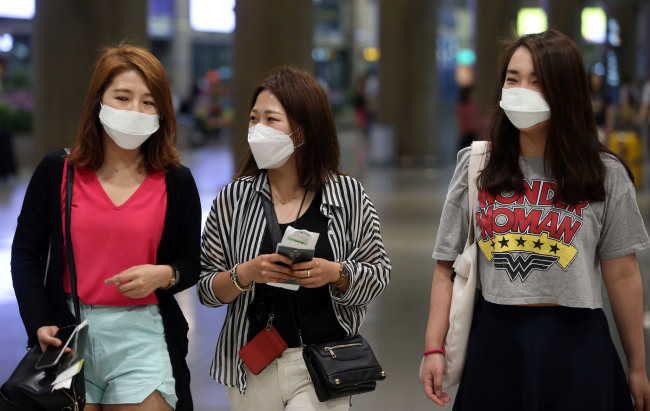 Travelers arrive at Incheon International Airport wearing masks
Monday as fears of MERS infection continue to spread. (Yonhap)