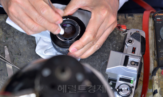 손한경 사장이 손님이 맡겨놓은 렌즈를 깨끗하게 닦고있다. 사진=이상섭 기자/babtong@heraldcorp.com