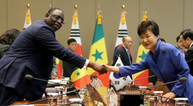 President Park Geun-hye and her Senegalese counterpart Macky Sall shake hands at a summit at Cheong Wa Dae on Thursday.   Yonhap
