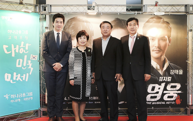 Hana Financial chairman Kim Jung-tai (right) and actor Song Il-guk (left) pose with attendants at the invitation event to the musical “Hero” in Seoul on May 20.   Hana Financial