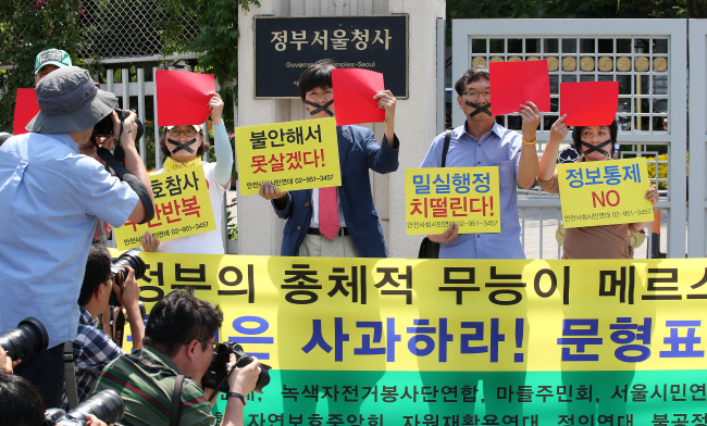 Members of civic groups hold a rally in front of the government complex in downtown Seoul on Thursday, protesting the government’s lax countermeasures against MERS and calling for transparent release of relevant information.   Yonhap