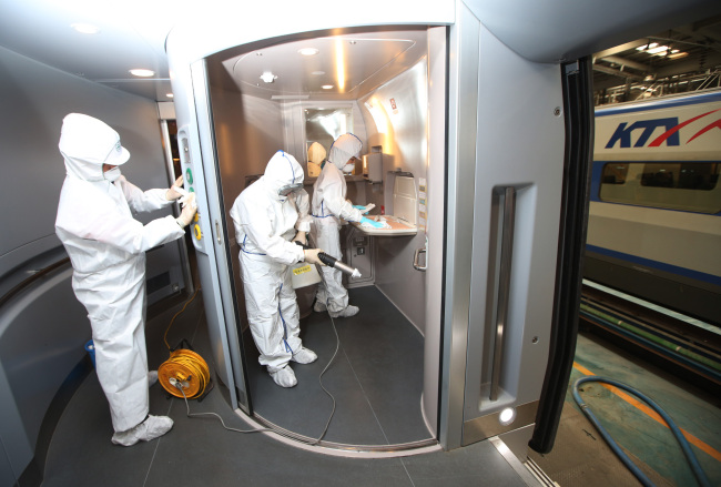 KTX officials sterilize the inside of a train in Goyang, Gyeonggi Province, in an effort to prevent the spread of MERS on Friday.   Yonhap