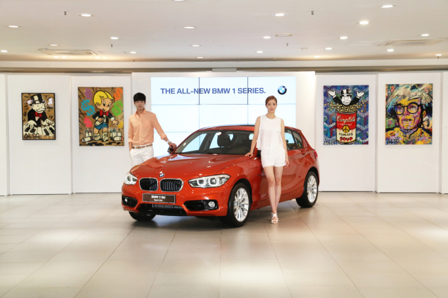 BMW Korea showcases the new BMW 118d, a facelift model based on the second-generation BMW 1 Series, in Seoul on Monday, alongside works by graffiti artist Alec Monopoly. The new 1 Series, geared toward younger drivers, boasts an improved design, a more powerful diesel engine and other upgraded features.   BMW Korea
BMW Korea showcases the new BMW 118d, a facelift model based on the second-generation BMW 1 Series, in Seoul on Monday, alongside works by graffiti artist Alec Monopoly. The new 1 Series, geared toward younger drivers, boasts an improved design, a more powerful diesel engine and other upgraded features.   BMW Korea