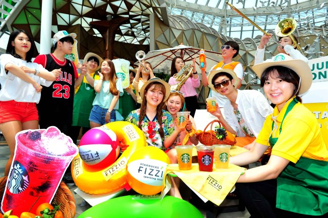 Staff members at the Starbucks Famille Park store in southern Seoul pose with the Mix Berry Fizzio, a premium handmade sparkling beverage made with fruits such as blueberries, raspberries and strawberries on Tuesday. A brass band and dance crew performed to mark the launch of the newest flavors of the best-selling fizzy drinks.   Starbucks Korea
Staff members at the Starbucks Famille Park store in southern Seoul pose with the Mix Berry Fizzio, a premium handmade sparkling beverage made with fruits such as blueberries, raspberries and strawberries on Tuesday. A brass band and dance crew performed to mark the launch of the newest flavors of the best-selling fizzy drinks.   Starbucks Korea