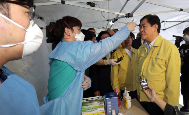 <YONHAP PHOTO-1881> 발열검사 받는 최경환 총리대행 (대전=연합뉴스) 배재만 기자 = 최경환 국무총리 직무대행이 9일 오전 대전 건양대학교병원을 방문, 메르스 선별 진료소에서 발열검사등 실제 환자들을 상대로 진료하는 상황을 체험해보고 있다. 2015.6.9 scoop@yna.co.kr http://blog.yonhapnews.co.kr/f6464/2015-06-09 15:48:08/ <저작권자 ⓒ 1980-2015 ㈜연합뉴스. 무단 전재 재배포 금지.>
Acting Prime Minister Choi Kyung-hwan (right) gets his fever checked during his visit to one of the affected hospitals in Daejeon, Tuesday.   Yonhap