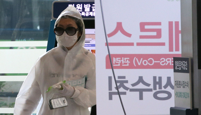 <YONHAP PHOTO-1662> '예방이 최선' (서울=연합뉴스) 박지호 기자 = 중동호흡기증후군(메르스) 감염을 예방하기 위해 우의와 마스크, 비닐 장갑 등으로 중무장한 한 시민이 10일 오전 일원동 서울삼성병원으로 들어가고 있다. 2015.6.10 jihopark@yna.co.kr/2015-06-10 14:04:26/ <저작권자 ⓒ 1980-2015 ㈜연합뉴스. 무단 전재 재배포 금지.>
A woman wearing a mask, plastic gloves and a raincoat enters Samsung Medical Center, one of the most heavily MERS-affected hospitals, in Ilwon-dong, southern Seoul, Wednesday.   Yonhap
A woman wearing a mask, plastic gloves and a raincoat enters Samsung Medical Center, one of the most heavily MERS-affected hospitals, in Ilwon-dong, southern Seoul, Wednesday.   Yonhap