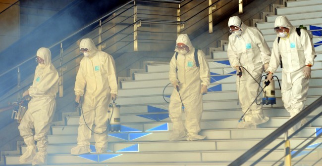 Quarantine officials sterlize a subway station in Wangsimni, Seoul, Thursday.    Yoon Byung-chan/The Korea Herald