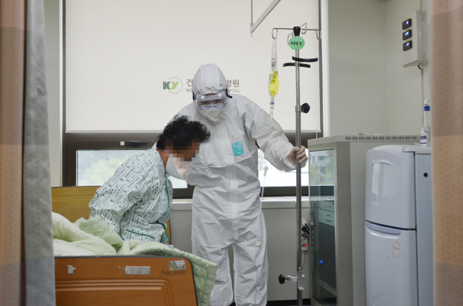 메르스 감염 확진자와 사망자가 나온 대전 건양대병원에서 한 간호사가 음압병실에 격리된 메르스 환자를 간호하고 있다(왼쪽). 메르스 병원 명단에 오른 의료진들에게 격려와 응원의 메시지를 남기고 있는 시민들 모습.