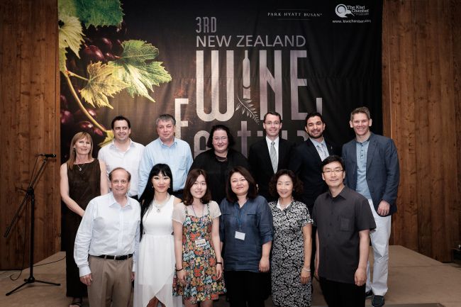 New Zealand Ambassador Clare Fearnley (back row, center) poses with board members and advisers of the Kiwi Chamber at the third annual New Zealand Wine Festival at the Park Hyatt Hotel in Busan on Saturday. Also attending were Park Hyatt Busan general manager Ross Cooper (back row, third from right), Kiwi Chamber chairman Simon Walsh (back row, second from right), New Zealand Embassy deputy head of mission John Riley (back row, right), and New Zealand Trade and Enterprise trade commissioner Ryer Freer (back row, second from left)  The festival was attended by over 330 people and featured over 75 New Zealand wines.   The Kiwi Chamber