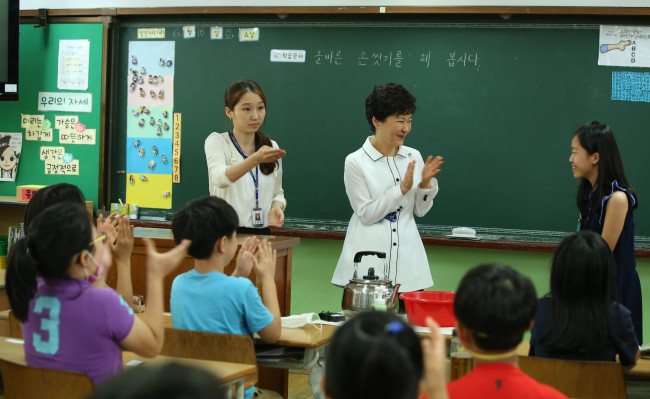 [硫붾Ⅴ?????愿??援먯쑁?꾩옣 諛⑸Ц/20150616/?쇱썝???紐⑥큹?깊븰援?諛뺤쥌洹?<br />諛뺢렐????듬졊??16???ㅼ쟾 ?쒖슱 ?쇱썝???紐⑥큹?깊븰援먮? 諛⑸Ц??硫붾Ⅴ???덈갑 援먯쑁??李멸??덈떎.  /泥????ъ쭊湲곗옄??以묒븰?쇰낫 諛뺤쥌洹?POOL/
President Park Geun-hye visits an elementary school in Seoul on Tuesday.   Park Hyun-koo/The Korea Herald