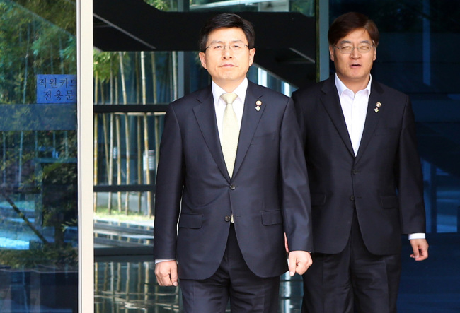 <YONHAP PHOTO-2195> 밖으로 나서는 황교안 (서울=연합뉴스) 최평천 기자 = 황교안 국무총리 후보자가 17일 오전 서울 종로구 금융연수원에 마련된 후보자 사무실에서 점심식사를 하기 위해 밖으로 나서고 있다. 2015.6.17 trump@yna.co.kr/2015-06-17 12:45:31/ <저작권자 ⓒ 1980-2015 ㈜연합뉴스. 무단 전재 재배포 금지.>
Prime Minister-designate Hwang Kyo-ahn (left) leaves his temporary office in Seoul on Wednesday.   Yonhap