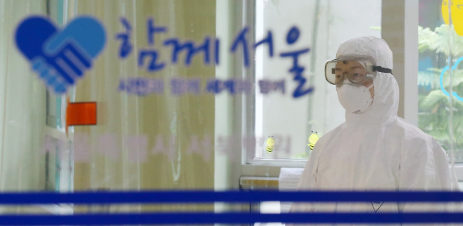 A medical staff member in protective clothing stands in the quarantine room at a hospital in Seoul, Sunday.   Yonhap
