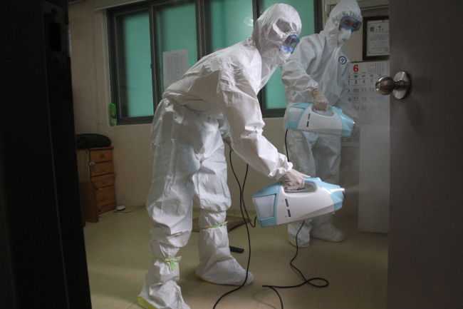 Fire fighters engage in an anti-infection campaign at a commnity center for senior citizens in Seoul on Thursday. (Yonhap)