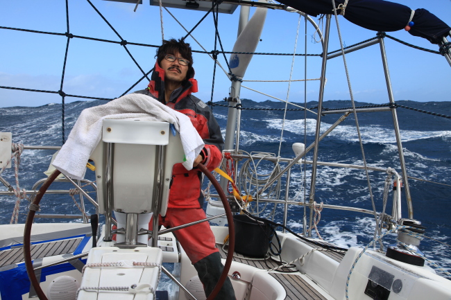 Kim Seung-jin stands at the steering wheel as the Arapani sails around the Cape of Good Hope on Feb. 22. (Kim Seung-jin)