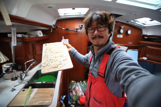 Kim Seung-jin poses as he prepares kalguksu in the Arapani’s cabin. (Kim Seung-jin)