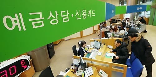Customers visit a bank branch in Seoul to receive consultations on account management.   Yonhap