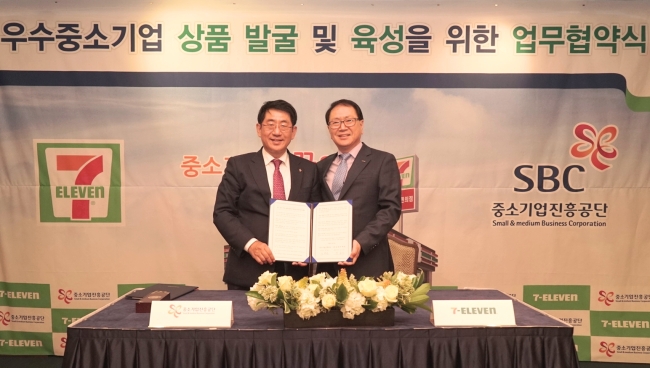 세븐일레븐의 정승인(오른쪽) 대표와 임채운 중소기업진흥공단 이사장이 업무협약서를 들고 기념촬영을 하고 있다.