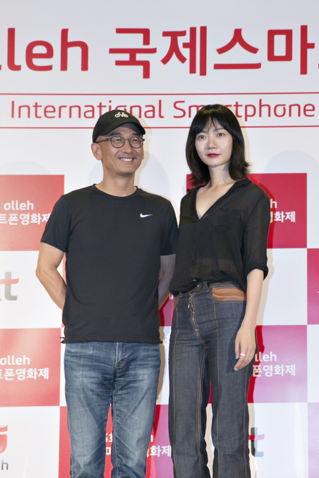 SMARTPHONE FILM FESTIVAL -- Movie director Lee Joon-ik (left) and actress Bae Doo-na, both of whom will be on a judging panel for the fifth olleh International Smartphone Film Festival, an annual event for films shot with smartphones, pose at a press meeting on Tuesday in Seoul.  KT