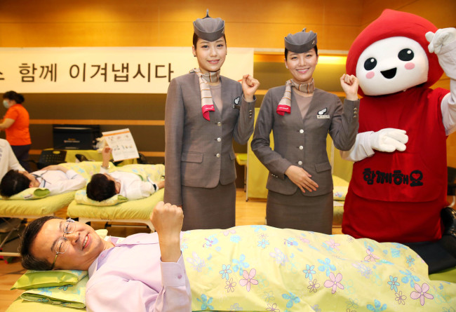 Asiana Airlines CEO Kim Soo-cheon participates in a blood donation campaign with other employees at the company’s headquarters in Seoul on Tuesday.   Asiana Airlines