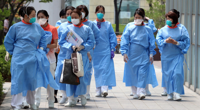 Medical staff walk in front of Konkuk University Medical Center, which has been partially shut down due to MERS, in eastern Seoul on Wednesday. (Yonhap)