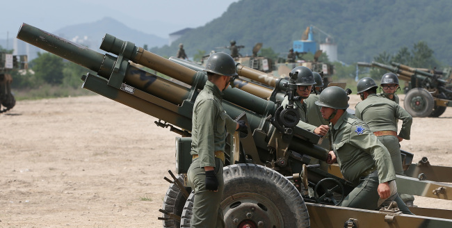 Artillerymen reenact a towed artillery mission wearing uniforms from the Korean War (1950-53) on the occasion of the 65th anniversary of the war outbreak at a firing range in Cheolwon, Gangwon Province, on Wednesday. Yonhap