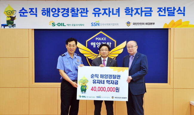 S-Oil senior vice president Lee Chang-jae (center) presents a scholarship of 40 million won to 20 children of fallen maritime police officers who died in the line of duty during a ceremony on Thursday. S-Oil has been running “The Hero Maritime Police Officers Support Program” since 2013.   S-Oil