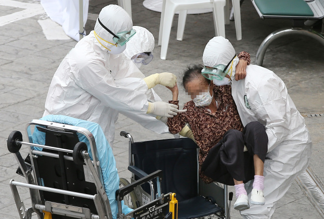Health care workers carry a suspected MERS patient at the Kyung Hee University Hospital at Gangdong in Seoul on Thursday. (Yonhap)