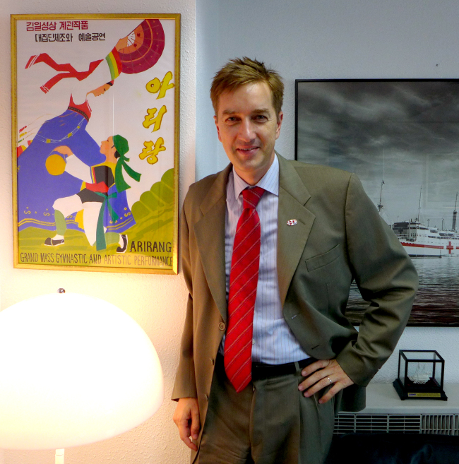 Danish Ambassador Thomas Lehmann poses beside an Arirang Mass Games poster he obtained on a visit to North Korea in late May.   Joel Lee/The Korea Herald
Danish Ambassador Thomas Lehmann poses beside an Arirang Mass Games poster he obtained on a visit to North Korea in late May.   Joel Lee/The Korea Herald