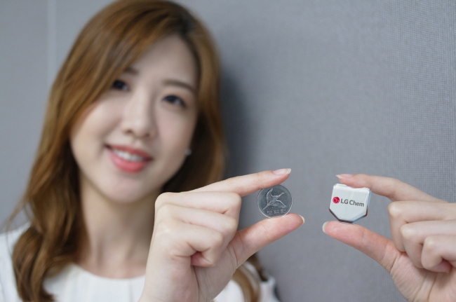An LG Chem staffer poses with the firm’s hexagonal battery.   LG Chem