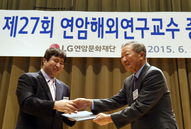 구본무LG그룹 회장(오른쪽)이 지난 29일 서울 여의도LG트윈타워에서 열린 제27회 연암해외연구교수 증서 수여식에서 조성재 대구대 직업재활학과 교수에게 증서를 전달하고 있다.