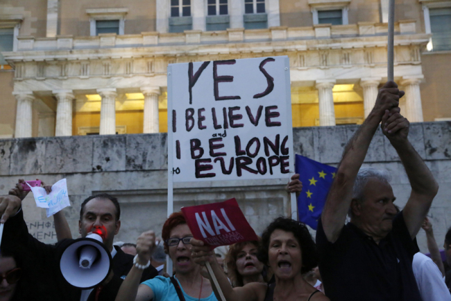 Demonstrators shout slogans during a rally organized by supporters of the YES vote for the upcoming referendum in front of the Greek Parliament in Athens, Tuesday. (AP-Yonhap)