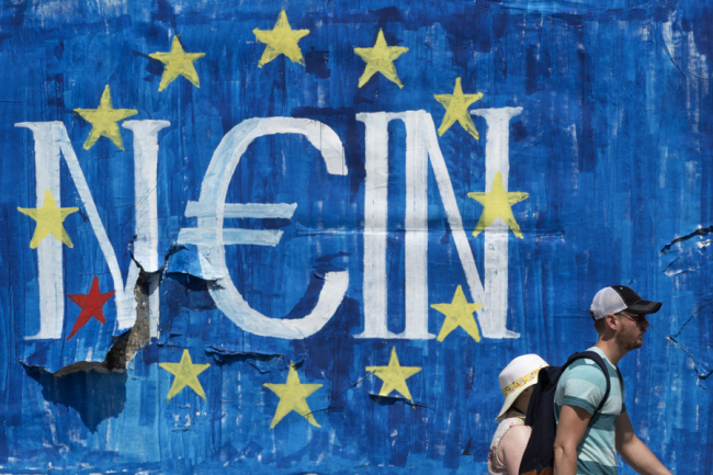ourists walks past a graffiti made by street artist N_Grams that read ''NO'' in German but also "YES, IN" in Greek language in Athens, on Sunday. (AP-Yonhap)