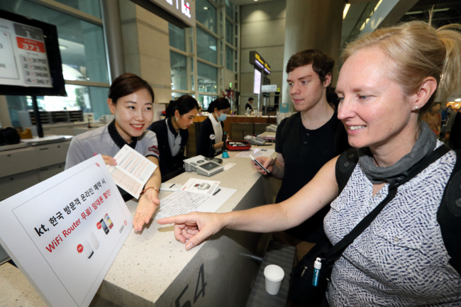 A KT official explains the firm’s Wi-Fi router rental service at the olleh Roaming Center at Incheon International Airport.   KT