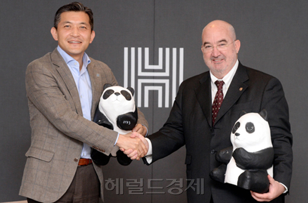 홍정욱(왼쪽) 헤럴드ㆍ올가니카 회장과 장 폴 패덱 WWF-Korea 이사장이 2일 서울 용산구 헤럴드스퀘어에서 한국의 생태발자국보고서 프로젝트의 지원 및 친환경 식품 장려 캠페인 전개 등을 내용으로 하는 양해각서(MOU)를 체결한 후, 친환경의 상징인 판다 인형을 들고 악수하고 있다. 박현구 기자/phko@heraldcorp.com