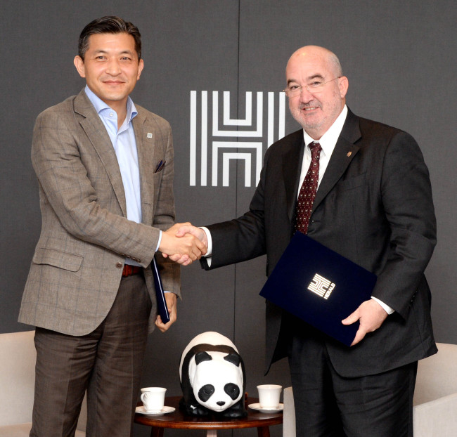 Chairman Jungwook Hong (left) of Herald Corp. shakes hands with World Wide Fund for Nature Korea Cochairman Jean-Paul Paddack after singing an MOU at Herald Square in Yongsan, Seoul, Thursday. Between the two chairmen is a panda figurine, an emblem of the “1600 Pandas World Tour” that started in 2008 as a collaboration between WWF and French artist Paulo Grangeon, now displayed in Jamsil, Seoul.   Park Hyun-koo/The Korea Herald