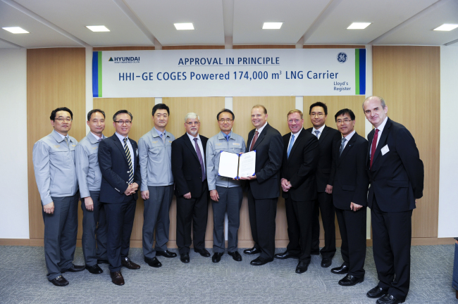 Hyundai Heavy Industries senior vice president Shin Hyun-soo (sixth from left) and GE Aviation Marine commercial marketing director Jeremy Barns (seventh from left) pose after receiving an approval in principle by Lloyd’s Register in the U.K. on Monday for developing an environmentally friendly, 174,000-square-meter liquid natural gas carrier with a gas turbine engine.    HHI